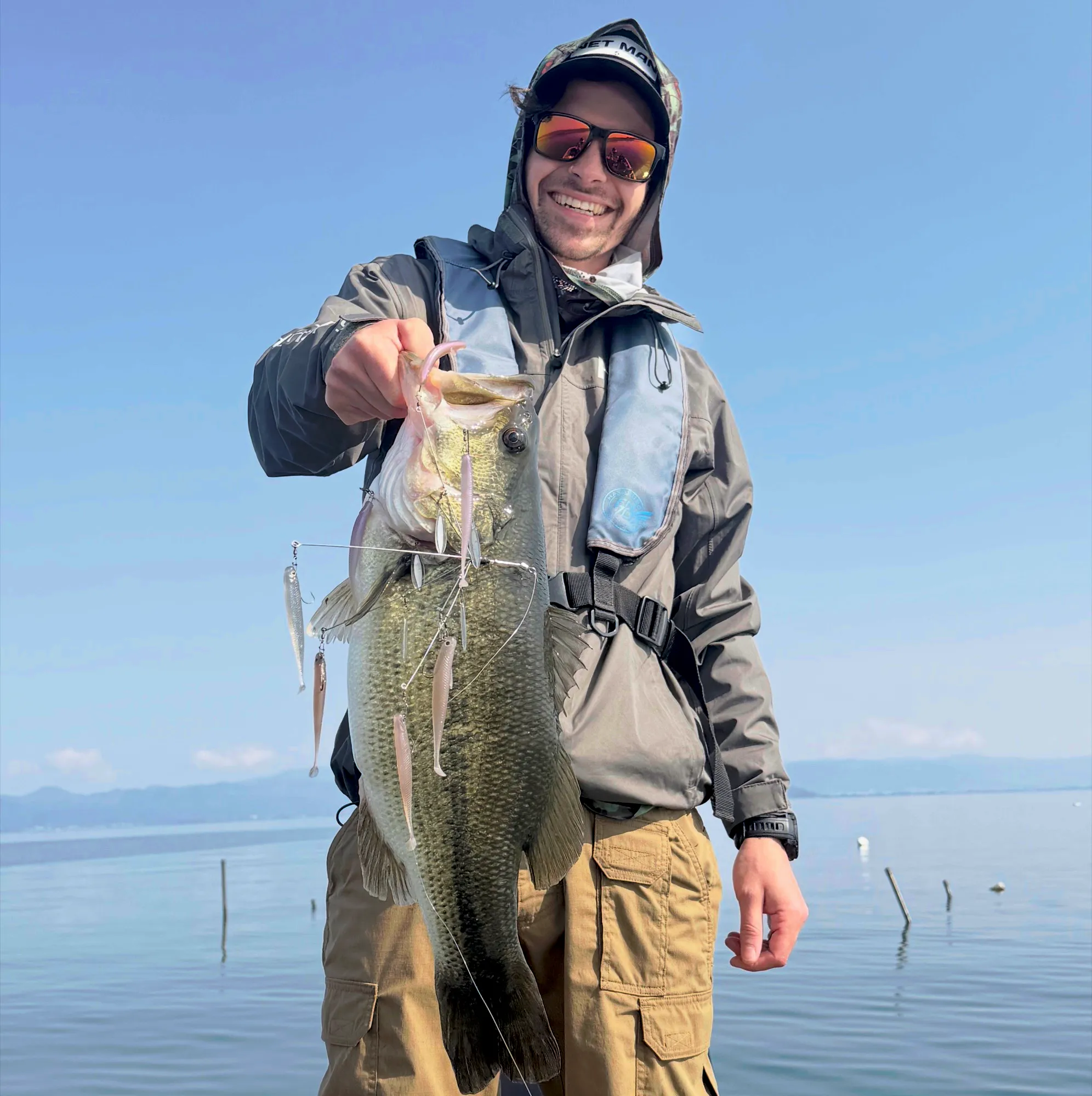 A guest holding a largemouth bass caught on an umbrella rig on Lake Biwa